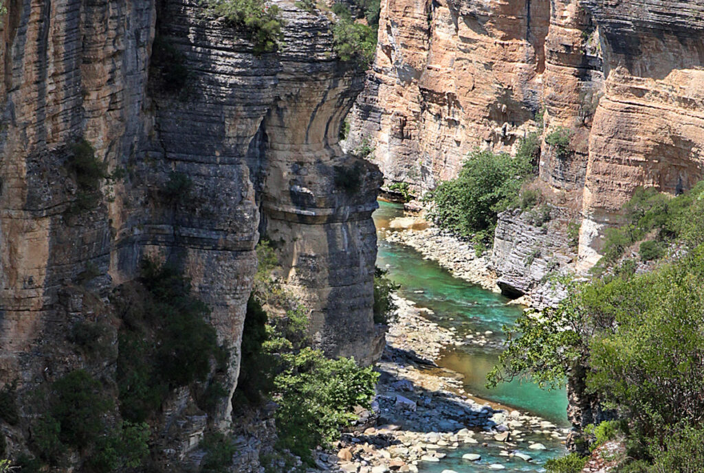 Explorers walking along a trail beside Osumi Canyon's dramatic rock formations