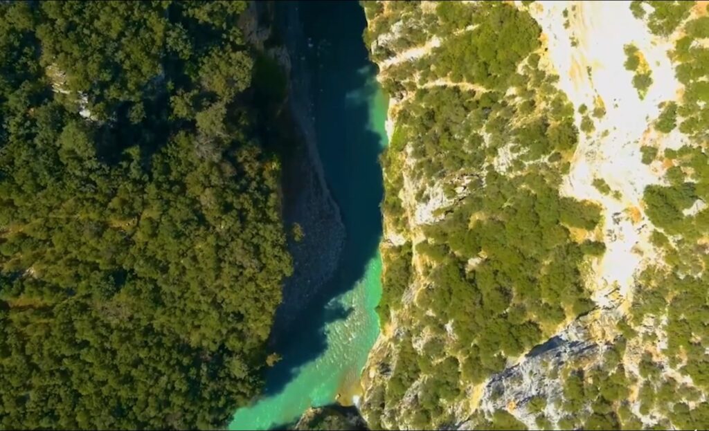 Colorful inflatable rafts navigating the winding Osumi Canyon river